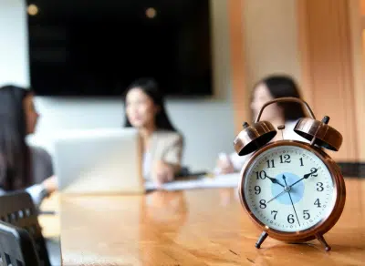 Reloj despertador sobre una mesa de reuniones en una oficina