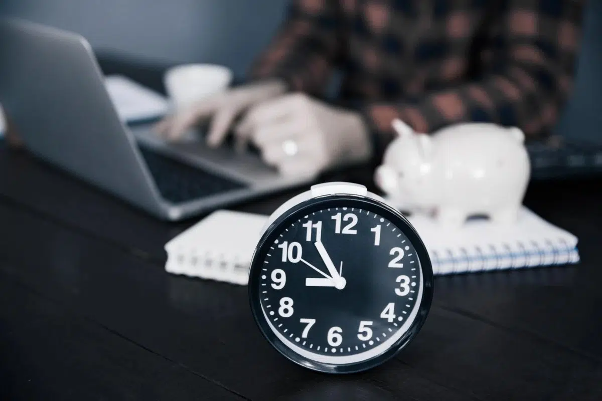 Trabajador junto a un reloj de escritorio durante un turno nocturno
